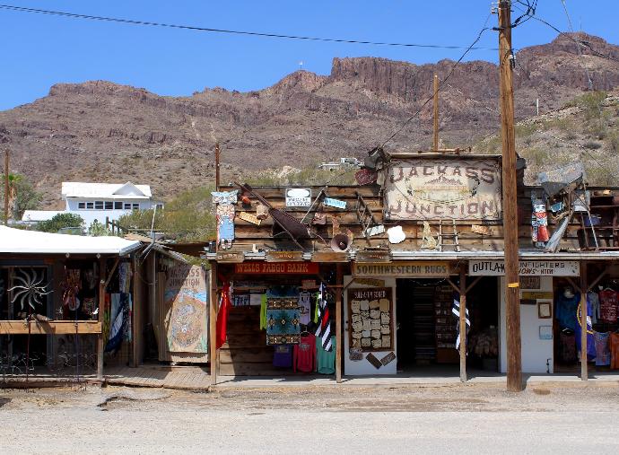 brown wooden building near mountain under blue sky during daytime