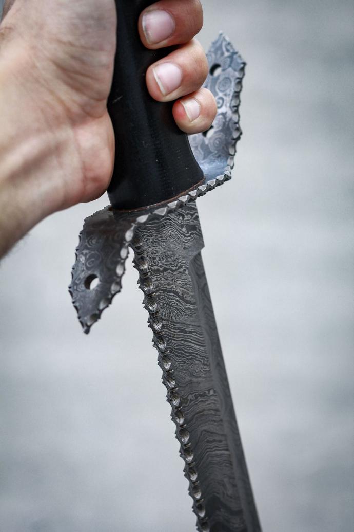 person holding black handle knife