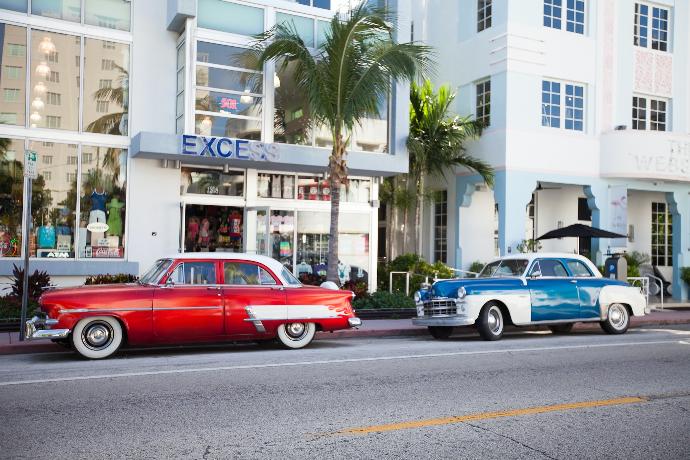 two classic cars parked on the side of the road