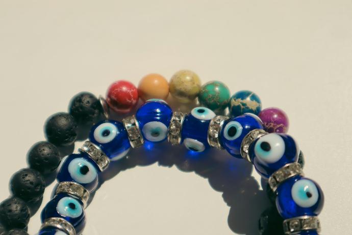 a bunch of bracelets with evil eyes on them